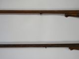 two old guns are hanging on a wall in a room