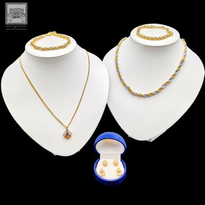 deux colliers et une bague présentés sur un fond noir