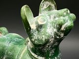 a green statue of a dog with a collar around it ' s neck