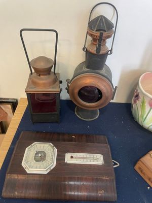 une table sur laquelle se trouvent divers objets, notamment une horloge, une lanterne et d'autres objets