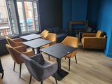 de nombreuses chaises et tables dans une pièce dotée d'une grande fenêtre
