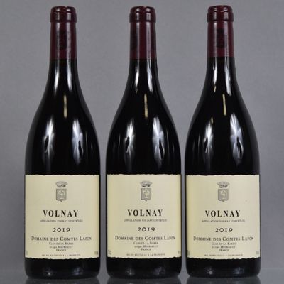 trois bouteilles de vin rouge posées sur une table