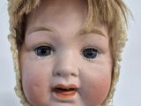 a close up of a baby doll with a hat on