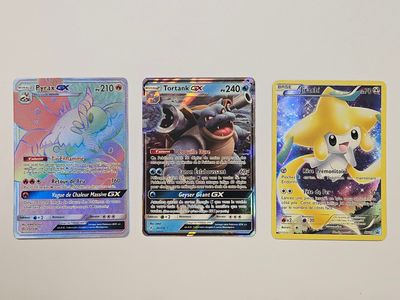 Quatre cartes Pokémon sont alignées sur une surface blanche