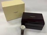 a close up of a watch sitting next to a box on a table