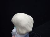 a hand holding a white sculpture of a person with a toothbrush