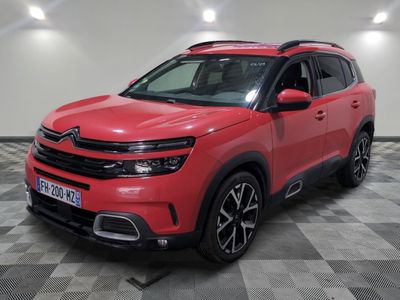un SUV Citroën rouge garé sur un sol à damier