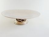 a white plate on a silver stand on a white background