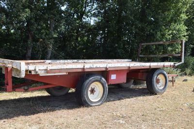 a red flat bed trailer parked in a field