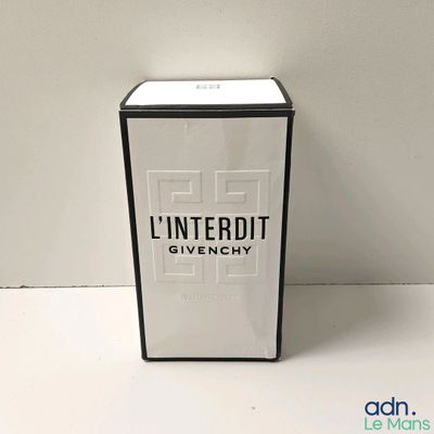 une photo d'un flacon de parfum posé sur une table