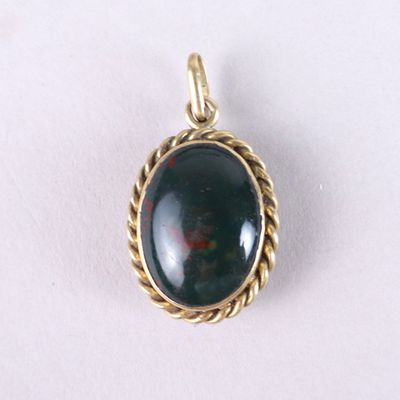 un gros plan d'un pendentif en pierre noire posé sur une surface blanche