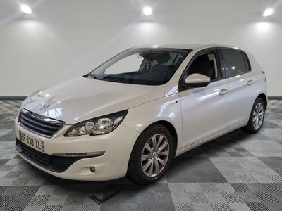 La petite voiture blanche est garée dans une grande pièce au sol à carreaux.