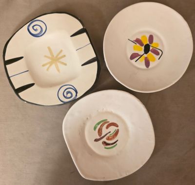 trois assiettes avec des motifs sont posées sur une table