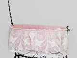 a white crib with a pink blanket on top of it