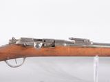 un gros plan d'un fusil exposé sur une surface blanche