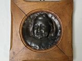 a picture of a bronze plaque of a man ' s face