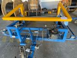 a blue cart with a yellow frame on it in a warehouse