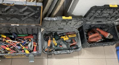 de nombreux outils différents rangés dans une mallette posée par terre