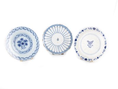 trois assiettes bleues et blanches à motifs sur une surface blanche