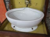 un lavabo blanc dans un meuble en bois, surmonté d'un miroir