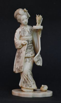 statue d'une femme vêtue d'un kimono, tenant un éventail et un oiseau