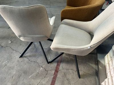 trois chaises de couleurs et de tailles différentes sont entreposées dans un entrepôt