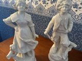 two figurines of a boy and a girl on a table