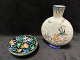deux vases et une assiette sont posés sur une surface noire