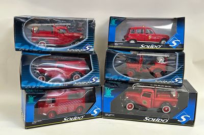 four red toy cars are in boxes on a white surface