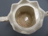 a close up of a white teapot on a table