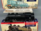 trois trains miniatures dans leurs boîtes, empilés les uns sur les autres sur une table