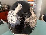 a black and white vase sitting on top of a glass table