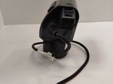 a black object on a white surface with a black cord