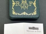 un gros plan sur un livre orné d'une abeille, à côté d'une carte de visite