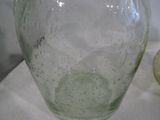 un vase en verre vert posé sur une nappe blanche