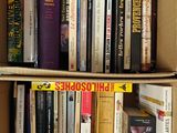 une boîte en carton remplie de livres posée sur une étagère