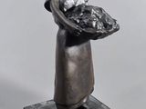 statue d'une femme tenant un panier de fruits sur un socle en marbre