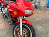 a red motorcycle parked on the side of the road