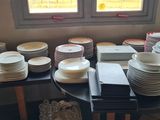 a lot of plates on a table with a window in the background