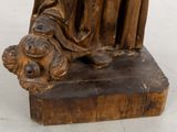a statue of a woman holding a baby on a wooden base