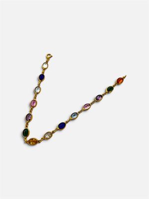 un bracelet en or avec des pierres multicolores sur fond blanc