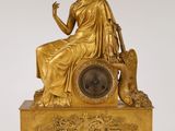 une image représentant une statue en or d'une femme assise au sommet d'une horloge