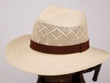 Le chapeau est en paille et est orné d'un ruban marron autour du bord