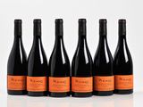 six bottles of wine are lined up in a row on a white surface