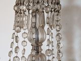 a glass chandelier hanging from the ceiling next to a lamp