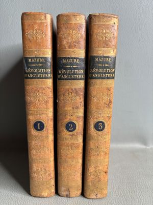 trois vieux livres posés l'un sur l'autre sur une table
