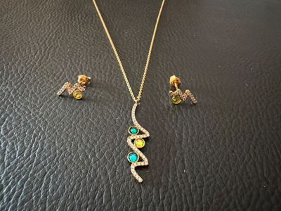 a close up of a necklace and earrings on a table
