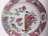 a plate that has a bird and flowers on it