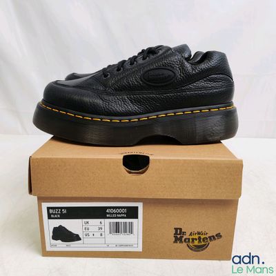 un gros plan sur une paire de chaussures noires posées sur une boîte