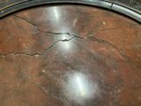 a crack in the top of a table with a clock on it